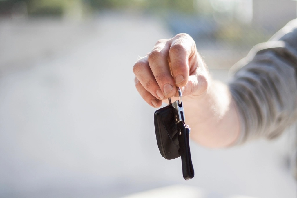 Hand holding out keys for a vehicle trade-in